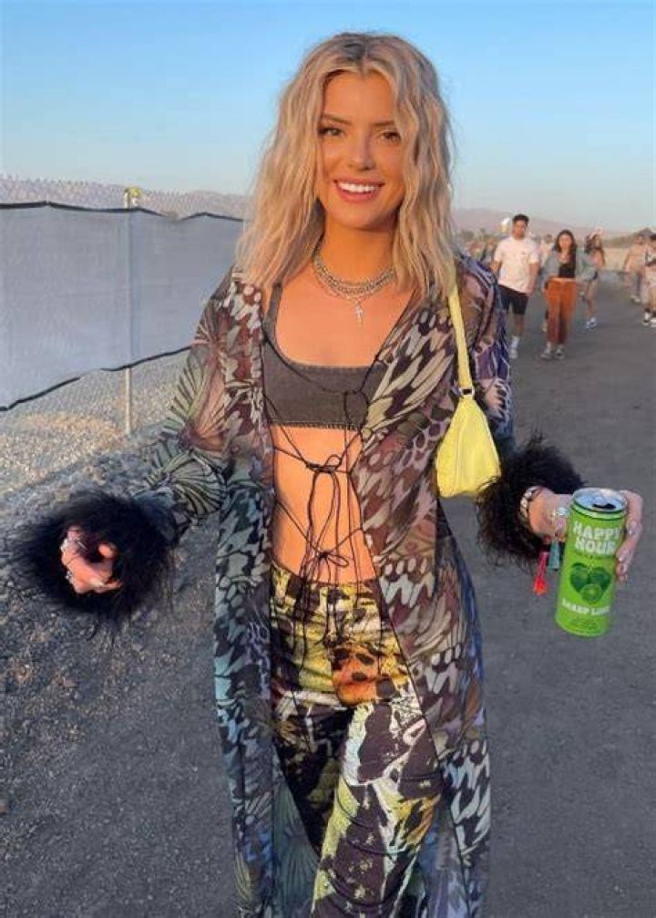 Alissa Violet walking with broken ribs and a fractured hip while holding a Happy Hour can in April 2022