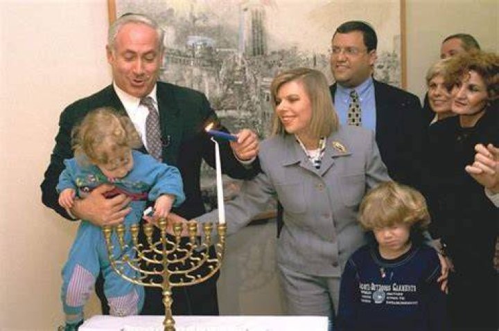 Benjamin Netanyahu seen lighting Hanukkah candles on the first night in the prime minister's office in Jerusalem with his wife Sara and their sons named Yair and Avner in 1996