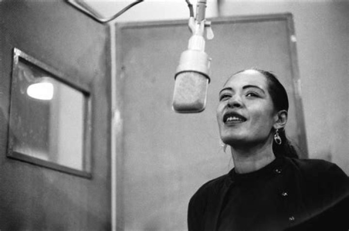 Billie Holiday smiling for a picture with her dog, Mister c. 1947