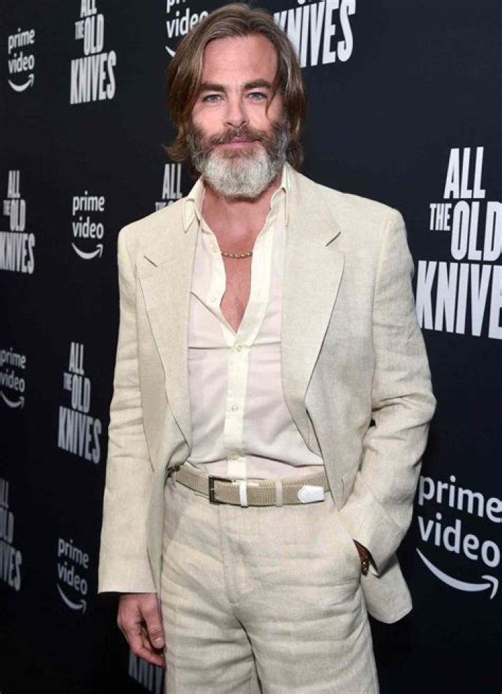 Chris Pine holding a guitar on his back