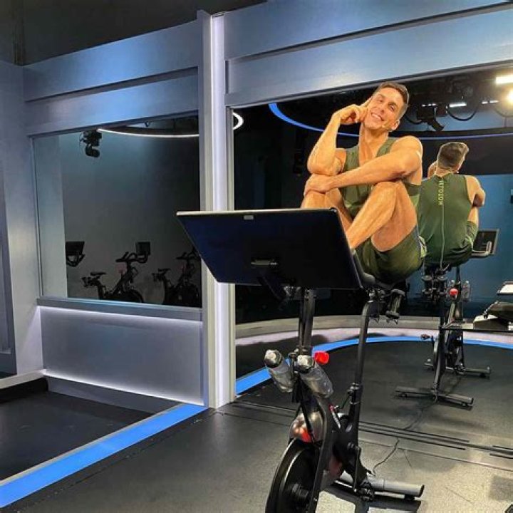 Cody posing with the Peloton brand logo in 2021