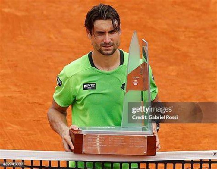 David Ferrer poses with the trophy after beating Czech player Tomas Berdych in the final of the Qatar Open at the Khalifa Tennis Complex in Doha in 2015