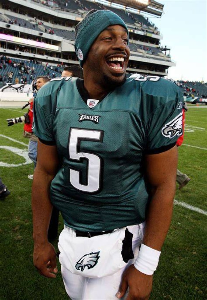 Donovan McNabb smiling for the camera as he signed a football jersey belonging to Storekeeper 2nd Class of Fleet Industrial Supply Center, Pearl Harbor in 2004