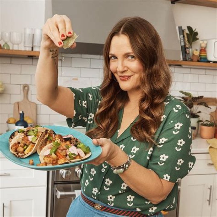 Drew Barrymore eating a slice of pizza