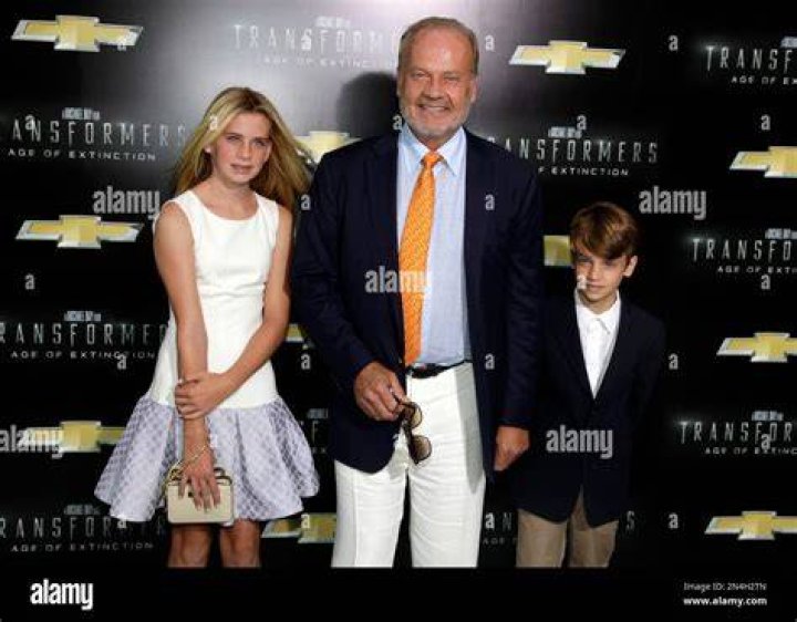 Kelsey Grammer (Center Right) and Hugh Jackman (Center Left) posing with crew members on the flight deck aboard the amphibious assault ship USS Kearsarge (LHD 3) in May 2006