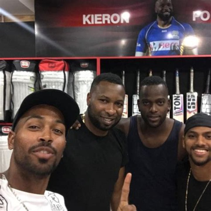Kieron posing with fellow players Hardik Pandya, Kevon Cooper, and Nicholas Pooran in June 2017