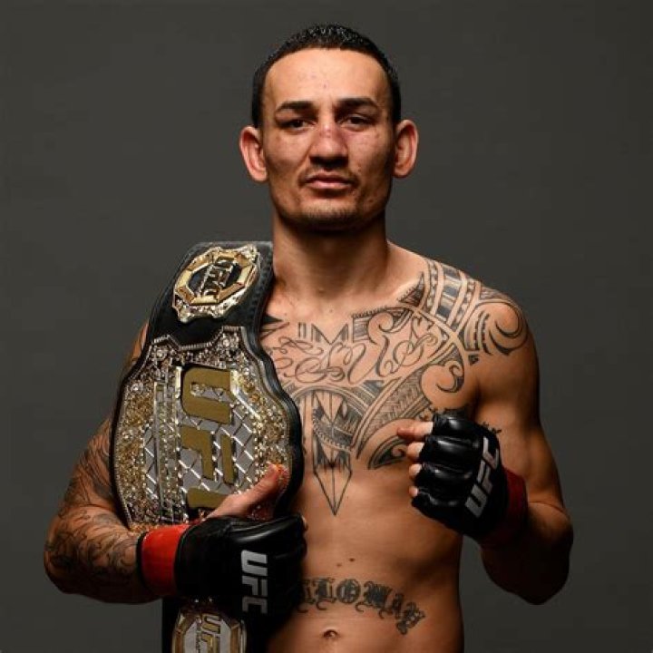 Max Holloway with a child from the audience holding his championship belt at the USO Spring Tour at Yokota Air Base Japan on April 22, 2018