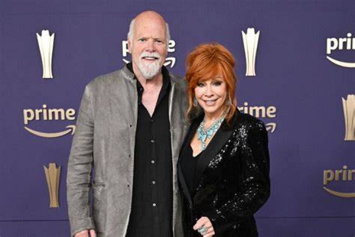 Rex Linn and Reba McEntire smiling for a picture while enjoying a dinner in January 2020