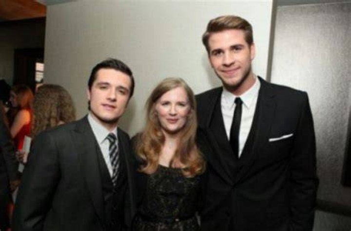Suzanne Collins as seen posing for a picture with Josh Hutcherson (left) and Liam Hemsworth