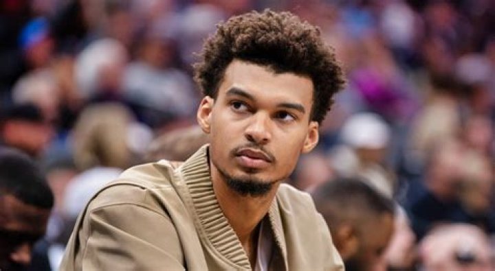 Victor Wembanyama sitting courtside at an NBA game in Paris, France in 2023